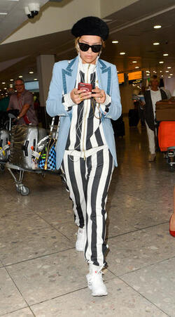 Rita Ora in a Striped Track Suit at Heathrow Airport