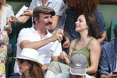 Jean Dujardin and his wife Nathalie Pechalat keep each other moisturised at the French Tennis Open at Roland Garros