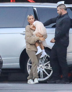 Kim Kardashian carrying a sleepy princess Nori