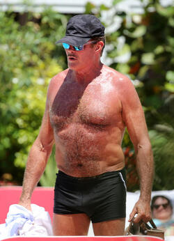 Baywatch actor David Hasselhoff wears tiny black swim trunks as he relaxes with his bikini clad finance Hayley Roberts by the pool in Miami.
