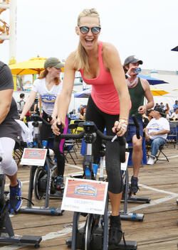 Molly Sims rides a stationary bike for charity