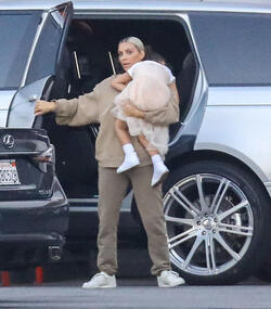 Kim Kardashian carrying a sleepy princess Nori
