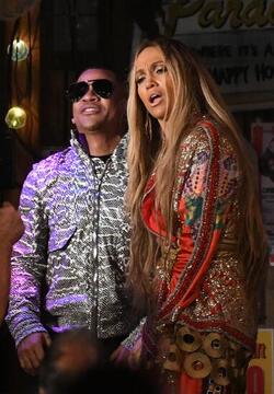 Jennifer Lopez wears a low cut red wrap dress with shimmering gold sequins as she is seen filming a music video