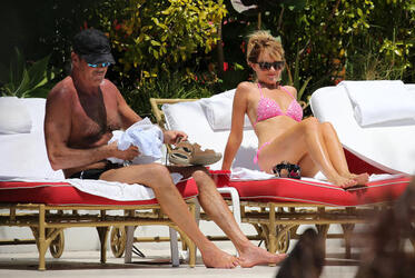 Baywatch actor David Hasselhoff wears tiny black swim trunks as he relaxes with his bikini clad finance Hayley Roberts by the pool in Miami.