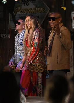 Jennifer Lopez wears a low cut red wrap dress with shimmering gold sequins as she is seen filming a music video