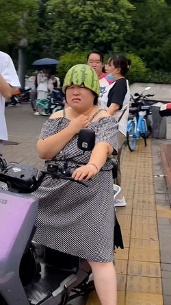 Woman Riding Scooter Uses Half Watermelon For Helmet